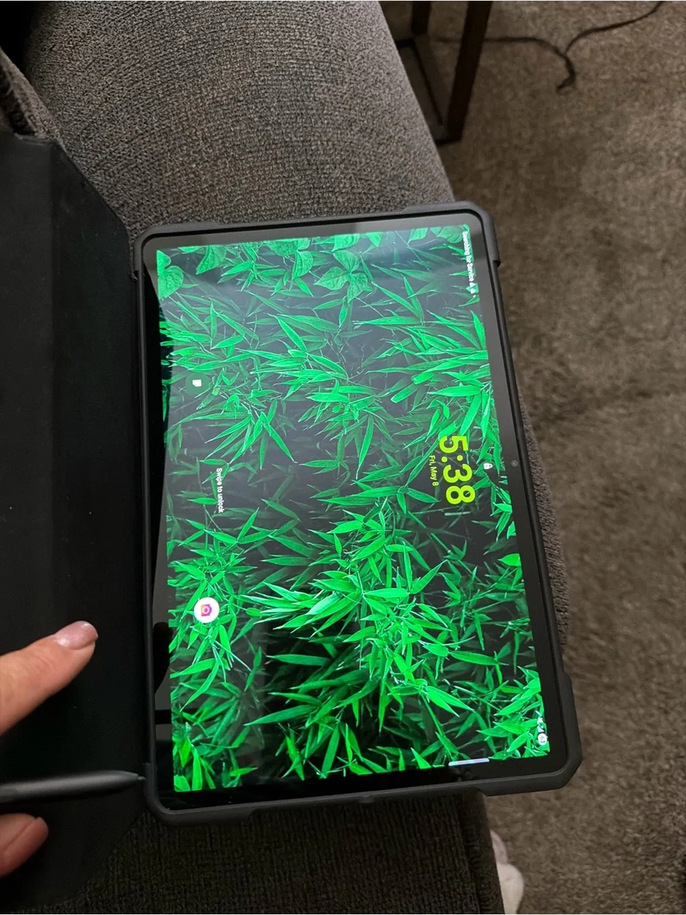 Samsung Tablet with Black Case and Green Wallpaper Display